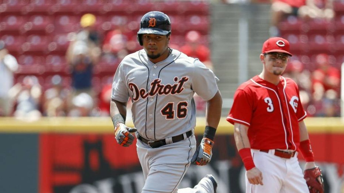 Detroit Tigers' Jeimer Candelario (46) runs the bases past Cincinnati Reds second baseman Scooter Gennett (3) after hitting a solo home run off starting pitcher Tyler Mahle in the first inning of a baseball game, Wednesday, June 20, 2018, in Cincinnati. (AP Photo/John Minchillo)