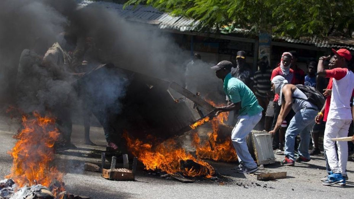 Demonstrators setup a barricade during a protest demanding to know how Petro Caribe funds have been used by the current and past administrations, in Port-au-Prince, Haiti, Wednesday, Oct. 17, 2018. Much of the financial support to help Haiti rebuild after the 2010 earthquake comes from Venezuela's Petro Caribe fund, a 2005 pact that gives suppliers below-market financing for oil and is under the control of the central government. (AP Photo/Dieu Nalio Chery)