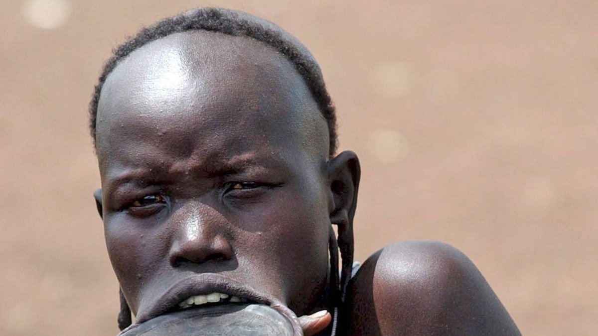 ETIOPIA- ELECCIONES:ETH01 PARQUE NACIONAL DE MAGO (ETIOPIA) 14/05/05 : Una mujer de la tribu Mursi, conocidos como la 'gente de la mañana', escucha a los ancianos durante una reunión sobre las elecciones de mañana en el Parque Nacional de Mago, a 550 kilómetros de Addis Abeba, hoy sábado 14 de mayo. Los Mursi, de los que sólo quedan unas 5.000 personas viviendo según las antiguas tradiciones, se adornan de forma elaborada, con turbantes, adornos tallados en los labios y cicatrices en forma de luna en los brazos de muchos de los hombres, cada una de ellas una insignia de honor que demuestra que han matado a un miembro de otra tribu. Los etíopes votan mañana domingo en unas elecciones que se consideran como una prueba de la voluntad del partido gubernamental por instaurar la democracia en el país. EFE/Stephen Morrison