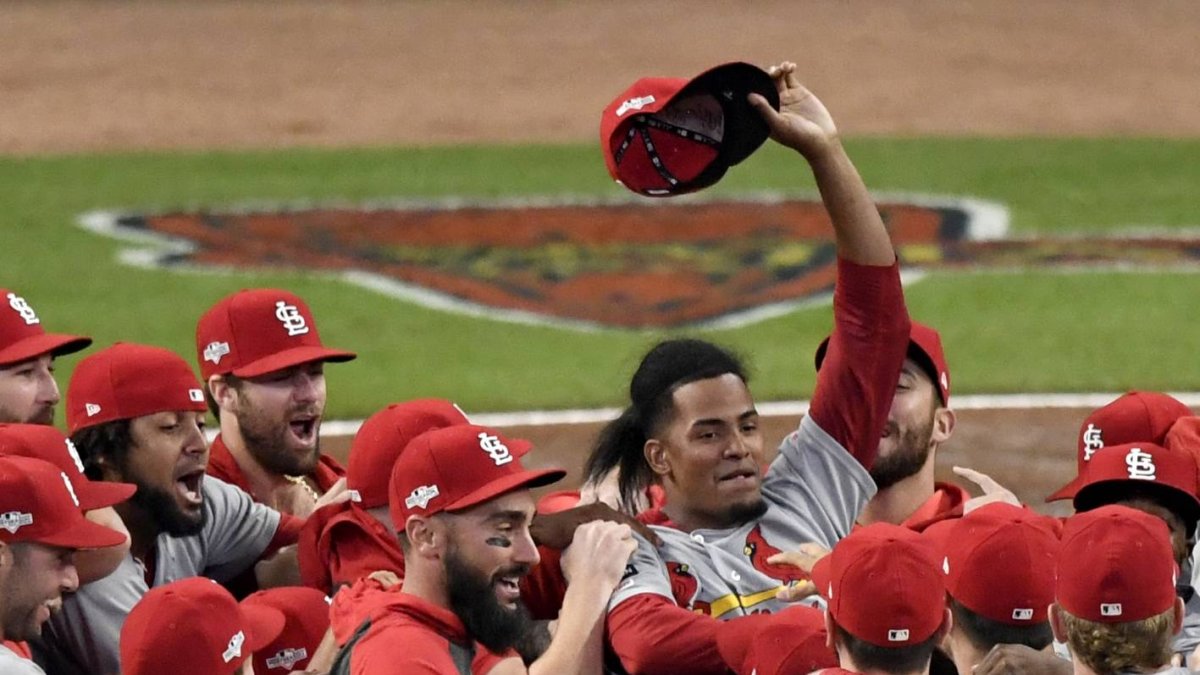 St. Louis Cardinals relief pitcher Genesis Cabrera waves his hat in the air as he celebrates with teammates after the Cardinals beat the Atlanta Braves 13-1 in Game 5 of their National League Division Series baseball game Wednesday, Oct. 9, 2019, in Atlanta. (AP Photo/Danny Karnik)