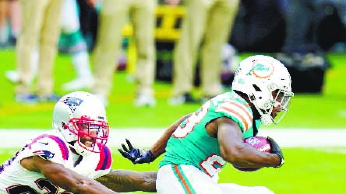 New England Patriots defensive back Justin Bethel (29) dives at Miami Dolphins' Noah Igbinoghene (23) during the second half of an NFL football game Sunday, Dec. 20, 2020, in Tampa, Fla. (AP Photo/Chris O'Meara)