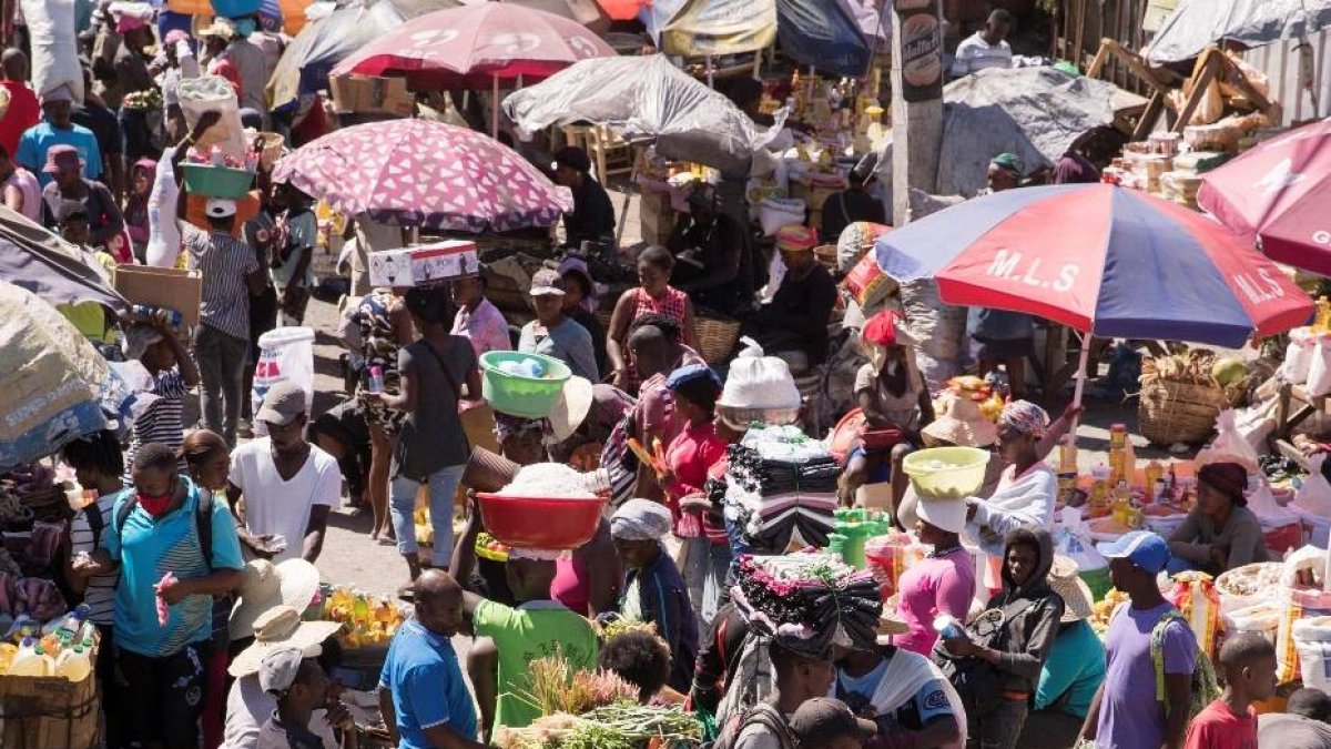 HAI01. PUERTO PRÍNCIPE (HAITÍ), 21/02/2021.- Clientes caminan entre los puestos de venta el 17 de febrero de 2021 en el mercado de Pétion Ville, en Puerto Príncipe (Haití). Con un año de pandemia a cuestas resulta imposible librarse del constante flujo de información sobre la covid-19 y tener la enfermedad en mente casi de forma constante, pero si alguien quiere olvidar el coronavirus que visite Haití, es un lugar donde se puede lograrlo. EFE/ Orlando Barría