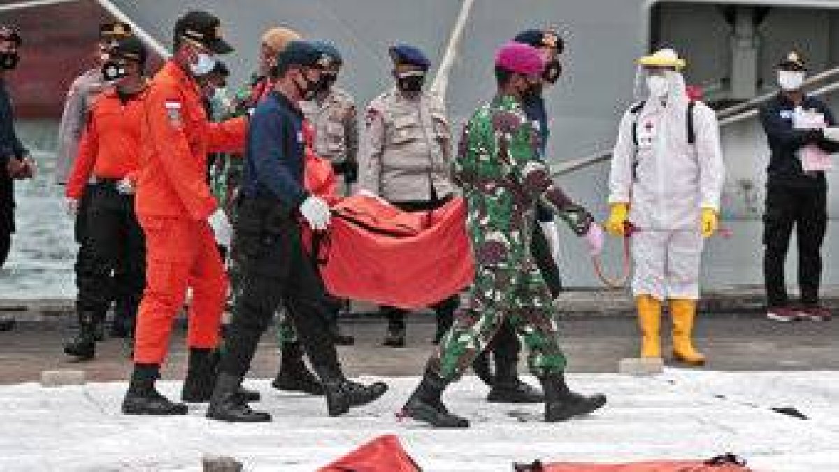 Rescatistas trasladan una bolsa con elementos recuperados tras el accidente de un avión de Sriwijaya Air, en el puerto de Tanjung Priok, Indonesia, el 12 de enero de 2021. (AP Foto/Dita Alangkara)