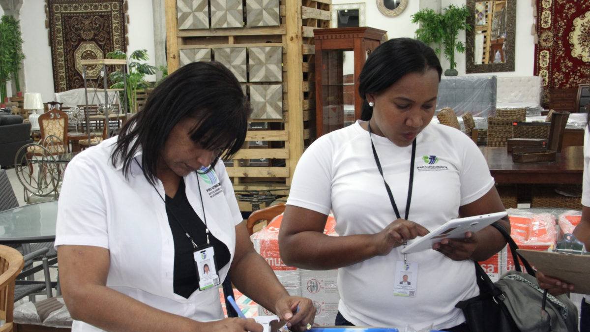 Analista de Publicidad y Precios e inspectora de Pro Consumidor observan ofertas en una tienda de la capital.