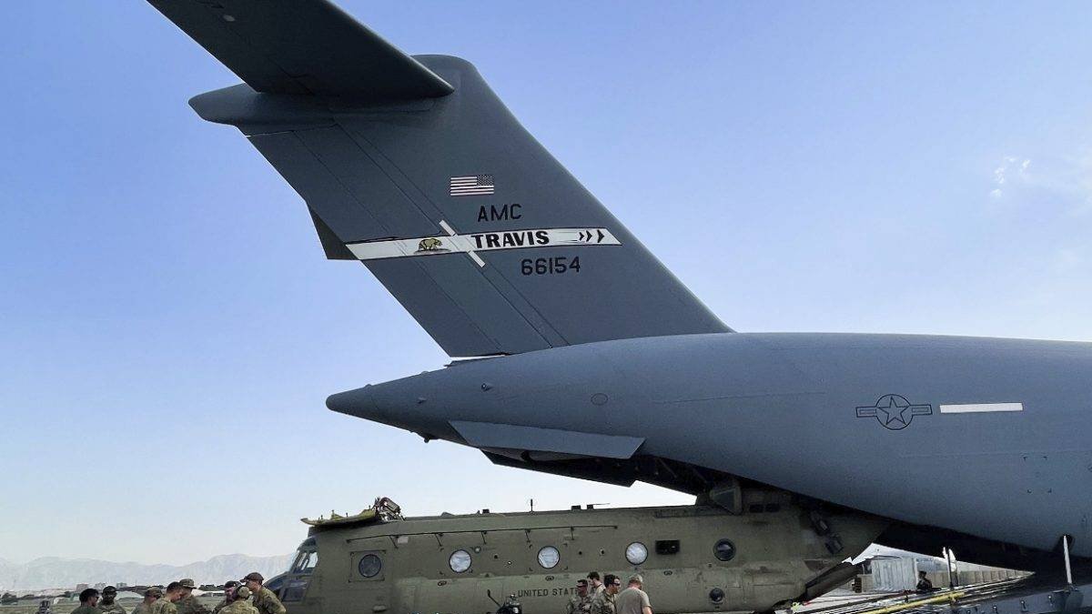 In this image provided by the Department of Defense, a CH-47 Chinook from the 82nd Combat Aviation Brigade, 82nd Airborne Division is loaded onto a U.S. Air Force C-17 Globemaster III at Hamid Karzai International Airport in Kabul, Afghanistan, Saturday, Aug, 28, 2021. (Department of Defense via AP)