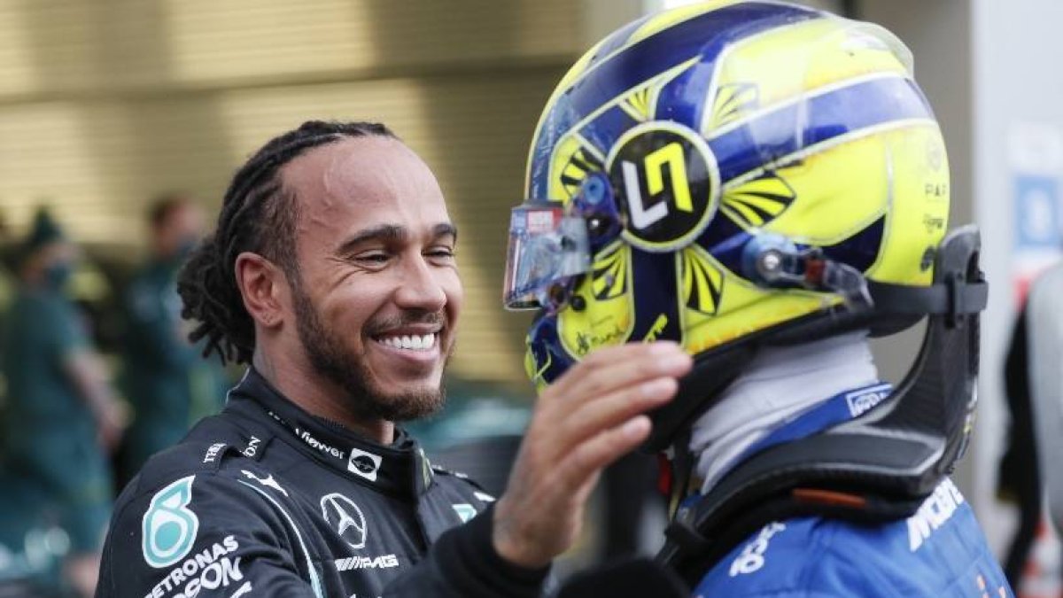 Mercedes' Lewis Hamilton, left, after winning the race with McLaren's Lando Norris at the Russian Formula One Grand Prix at the Sochi Autodrom circuit, in Sochi, Russia, Sunday, Sept. 26, 2021. (Yuri Kochetkov/Pool Photo via AP)
