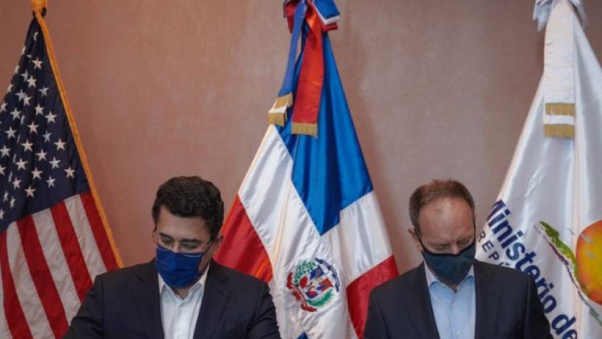 David Collado y representante de agencia firman acuerdo.