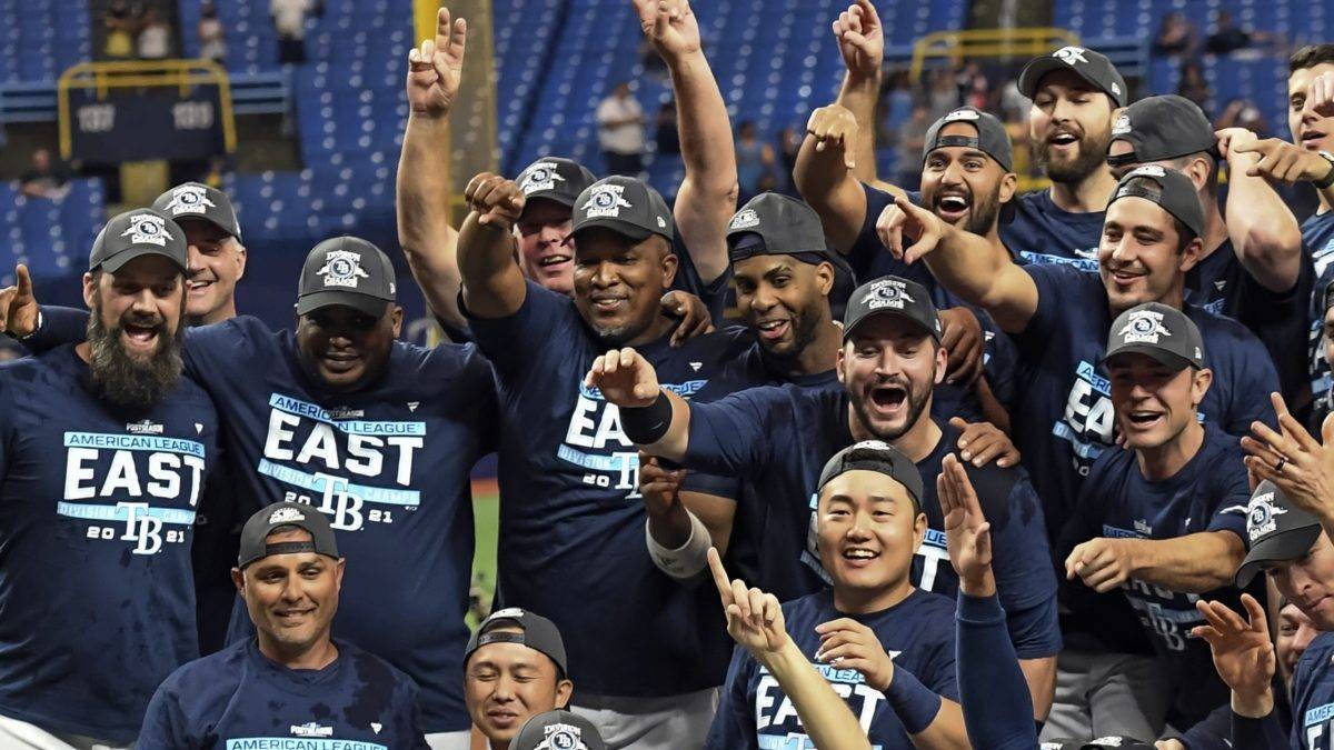 Tampa Bay Rays' Randy Arozarena dives into the gathering of players and coaches as they celebrate after defeating the Miami Marlins 7-3 to clinch the American League East during a baseball game Saturday, Sept. 25, 2021, in St. Petersburg, Fla. (AP Photo/Steve Nesius)