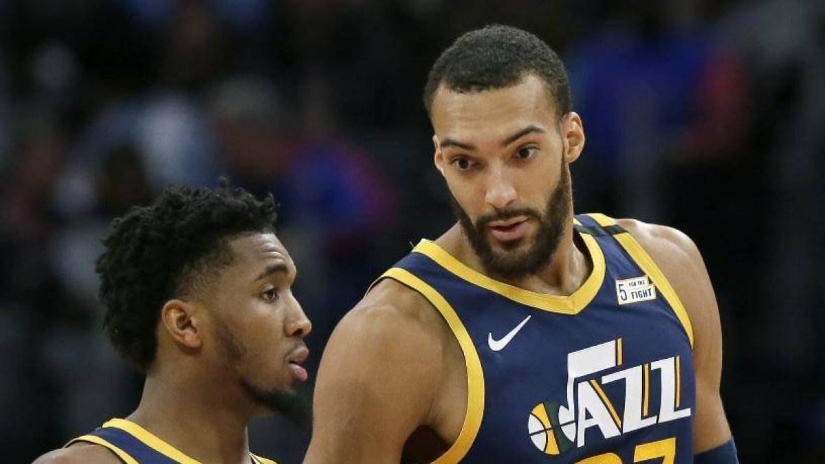 Donovan Mitchell, izq, y Rudy Gobert (27) en acción.