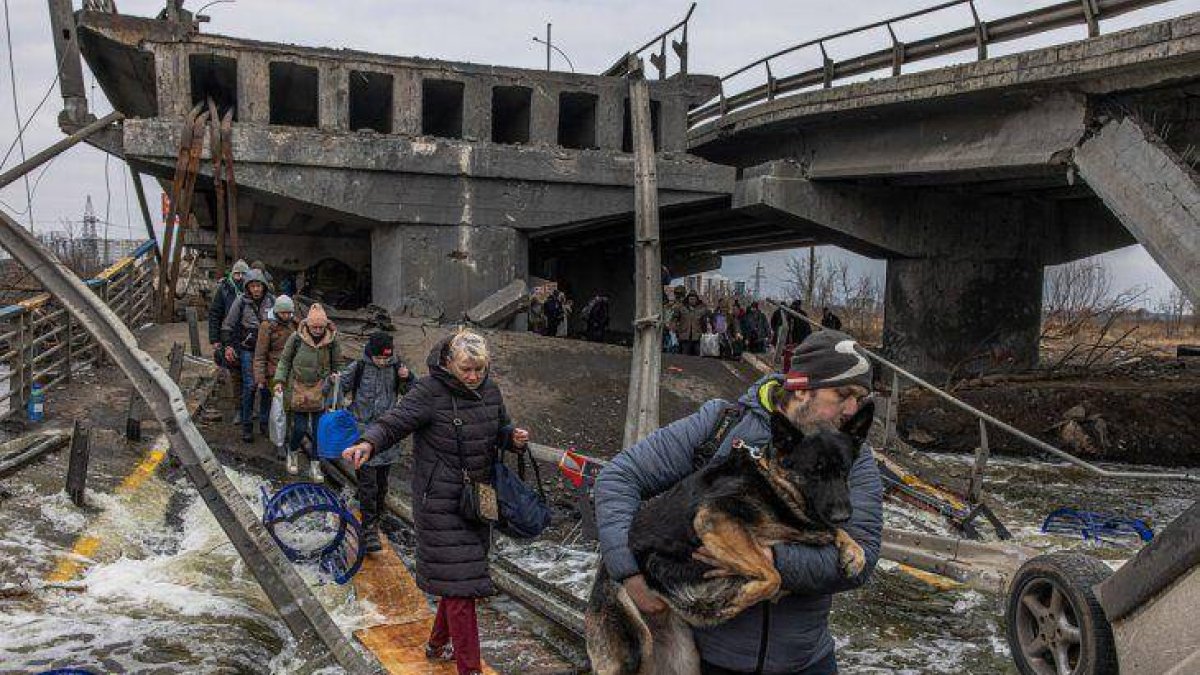 Civiles cruzan un puente destruido cerca de Kiev.