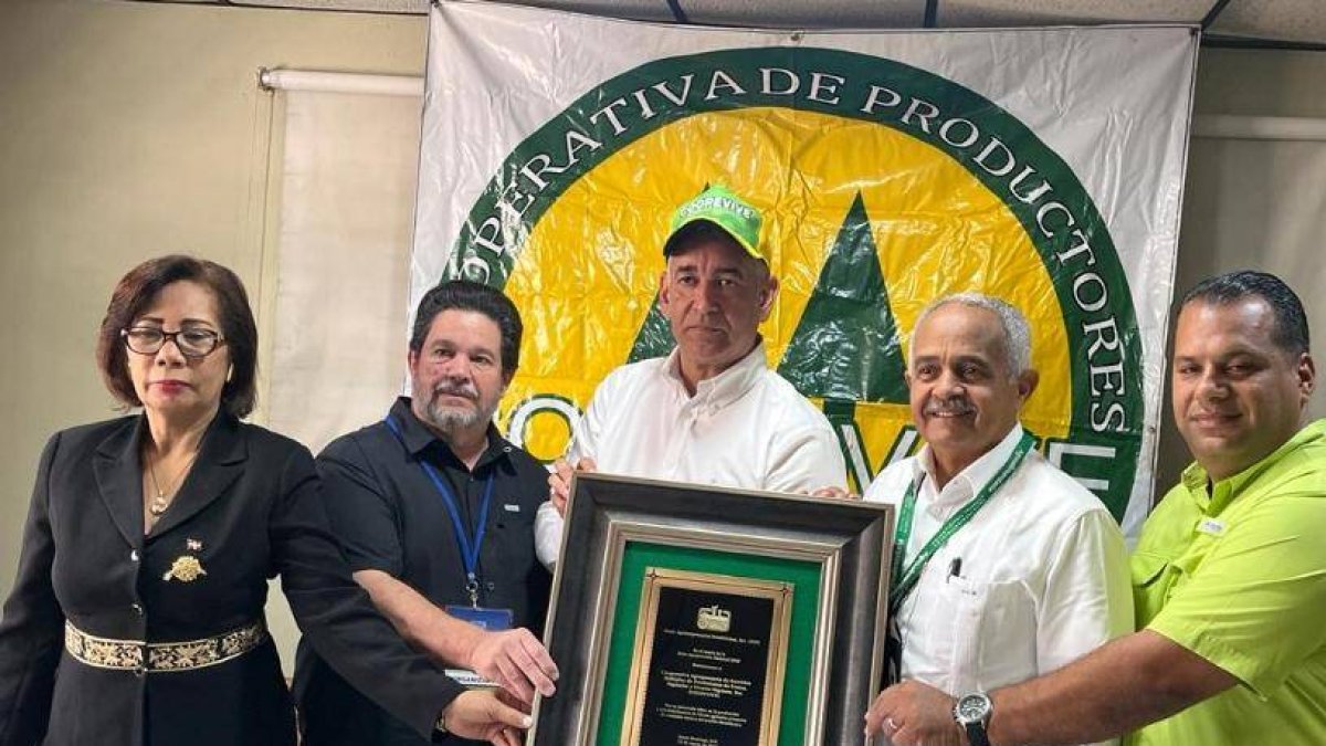 Osmar Benítez entrega placa a Alex Cruz González.