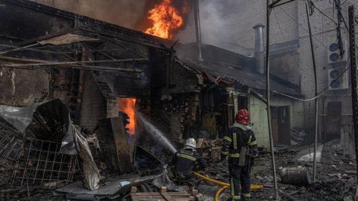 bomberos combaten el fuego en un almacén que fue alcanzado por el bombardeo ruso, en Kharkiv. Ucrania.