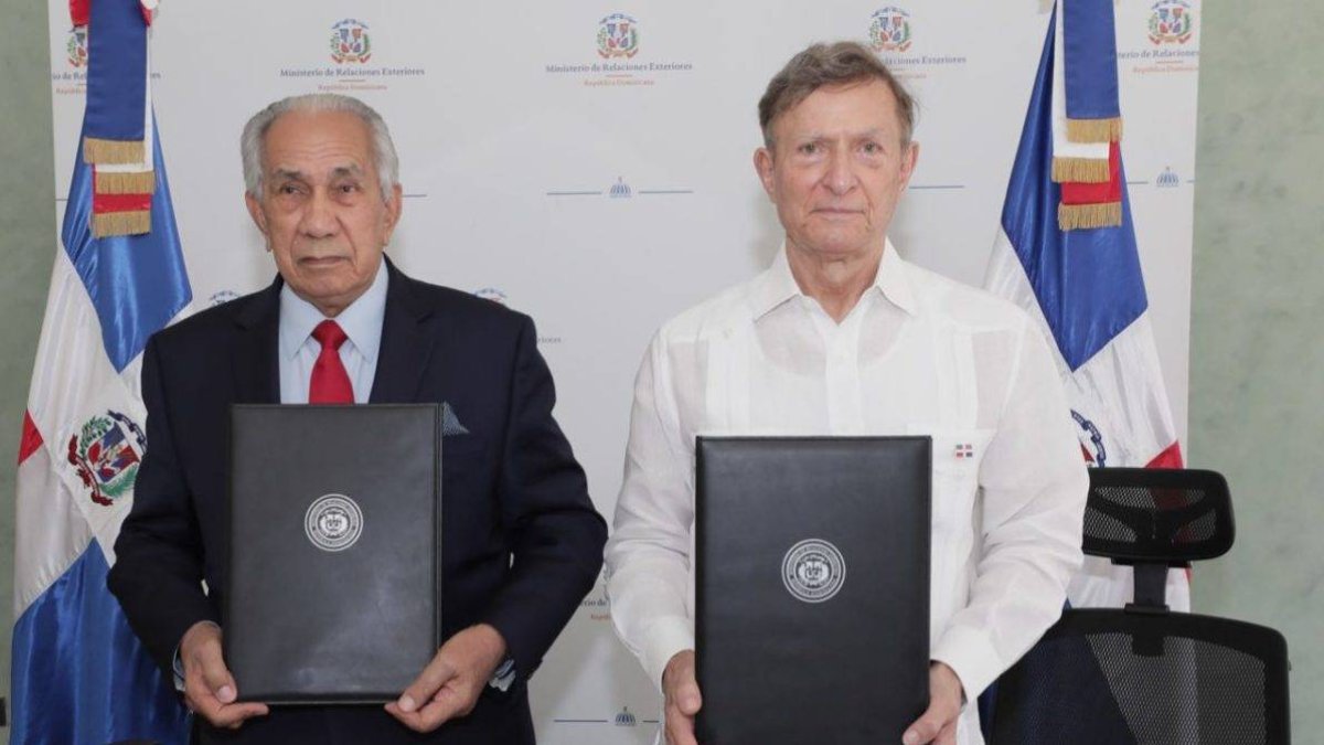 Ejecutivos de ambas entidades posan para una foto tras firma de acuerdo.