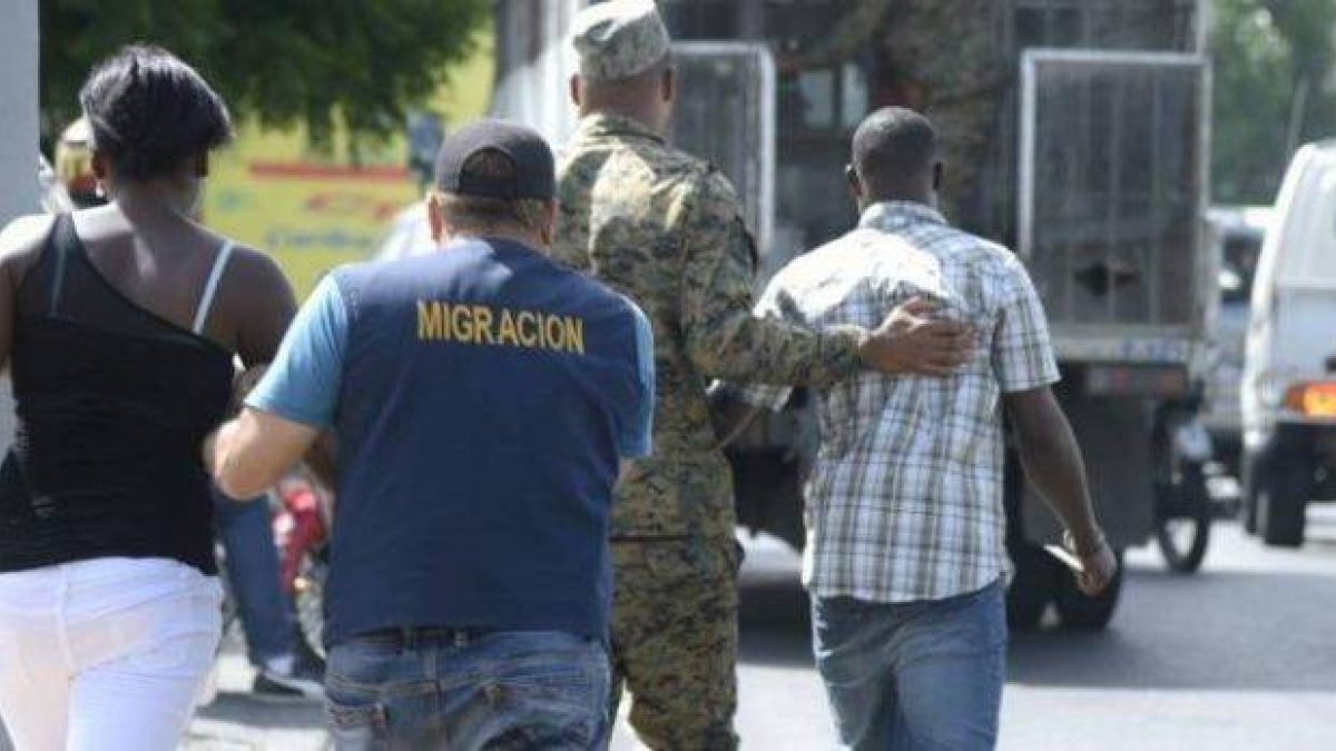 Ciudadano haitiano es conducido por oficiales de la Dirección General de Migración (DGM).