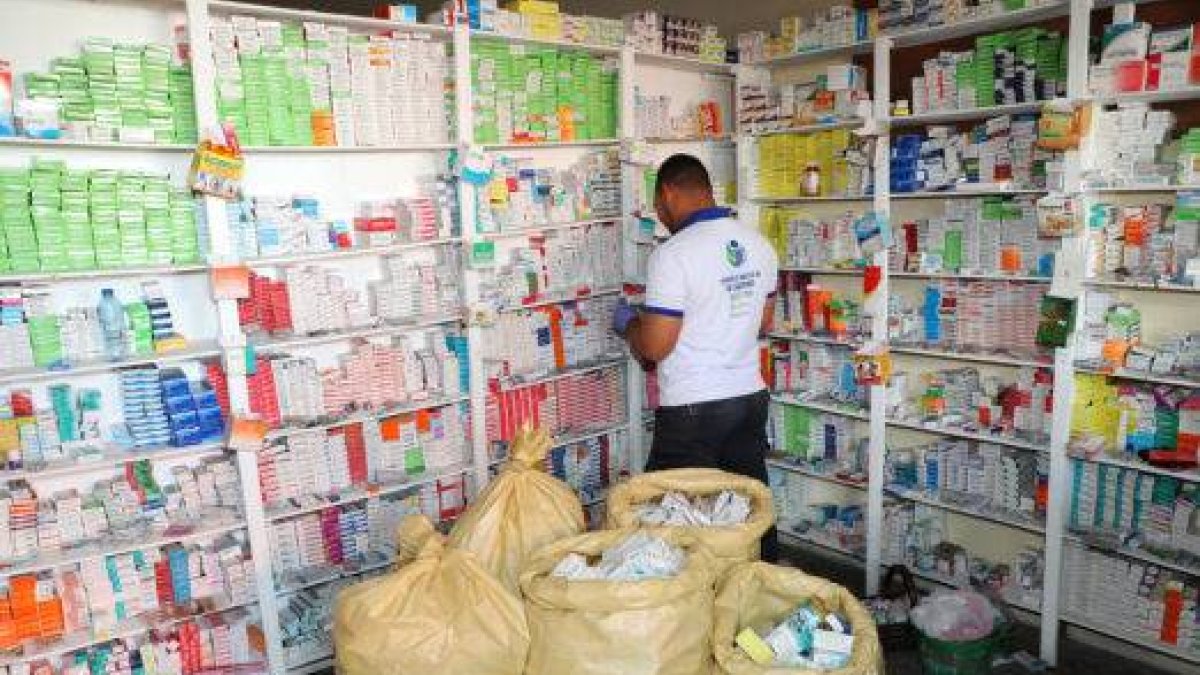 Uno de los inspectores de Pro Consumidor verifica medicamentos en uno de los negocios durante el operativo realizado por esa institución en este municipio.