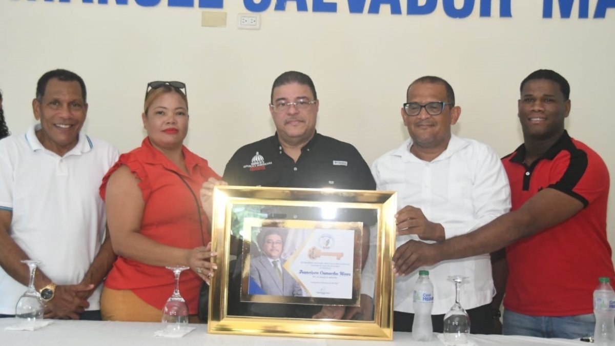 Francisco Camacho recibe una placa de manos del alcalde Carlos Rodríguez Matos. Figuran, Dagoberto Rodríguez, senador electo por la provincia de Independencia, así como los regidores Ana Mercedes Vargas y Cheify Marmolejos.