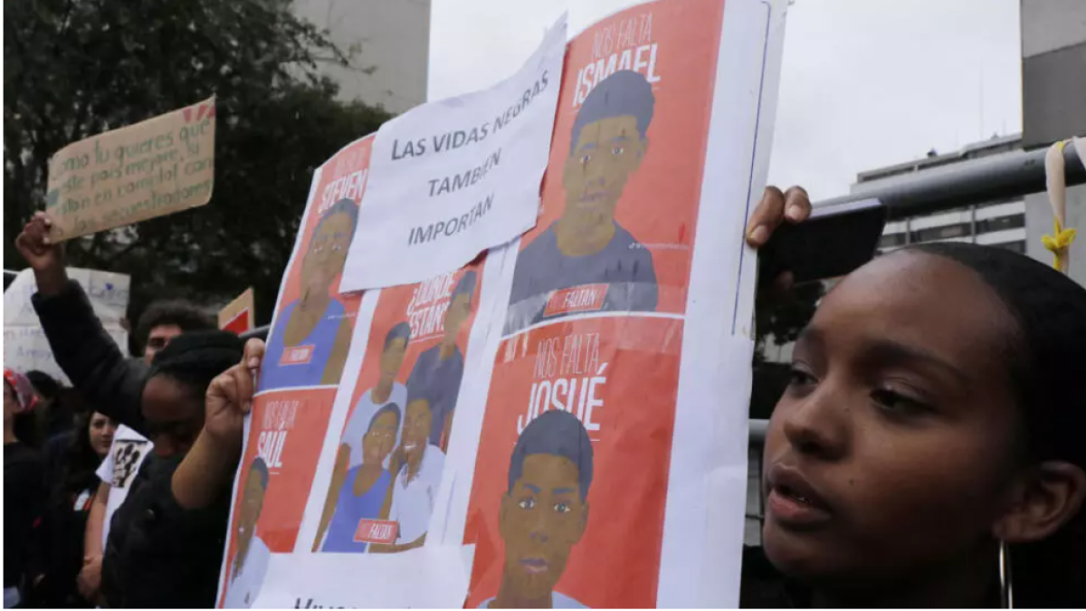 Una mujer muestra una pancarta con la foto de los menores desaparecidos en una manifestación en Quito, el 23 de diciembre de 2024. © GALO PAGUAY - AFP