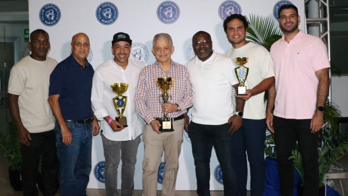 Directivos y entrenadores del Club Naco, reciben el trofeo de campeón.