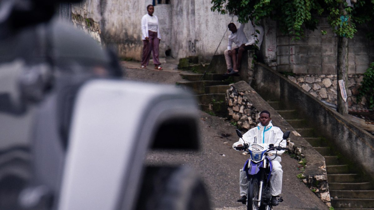 AME997. PUERTO PRÍNCIPE (HAITÍ), 23/10/2025.- Un hombre con un traje de protección transita en su motocicleta este jueves, en Puerto Príncipe (Haití). La tormenta tropical Melissa, que sigue avanzado lentamente por el Caribe, se cobró su primera víctima mortal en Haití, uno de los países más expuestos en la última década a los desastres naturales y que se enfrenta actualmente a serios problemas de infraestructuras para hacer frente a cualquier tipo de emergencia. EFE/ Mentor David Lorens