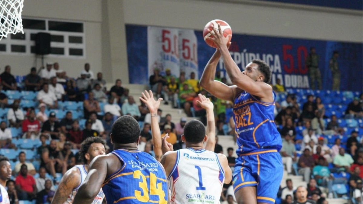 Rafael Bautista se dirige rumbo al canasto, mientras que en la gráfi ca principal, Gerardo Suero se dispone a realizar un lance durante el partido de anoche