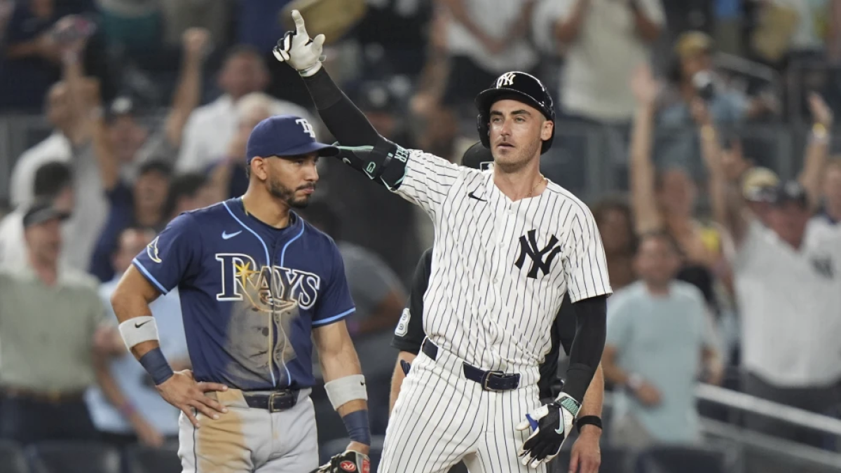 El campocorto de los Rays de Tampa Bay, José Caballero, observa mientras Cody Bellinger de los Yankees de Nueva York gesticula a sus compañeros después de batear un triple productor de carrera durante la décima entrada de un partido de béisbol el miércoles 30 de julio de 2025, en Nueva York. (AP Photo/Frank Franklin II)