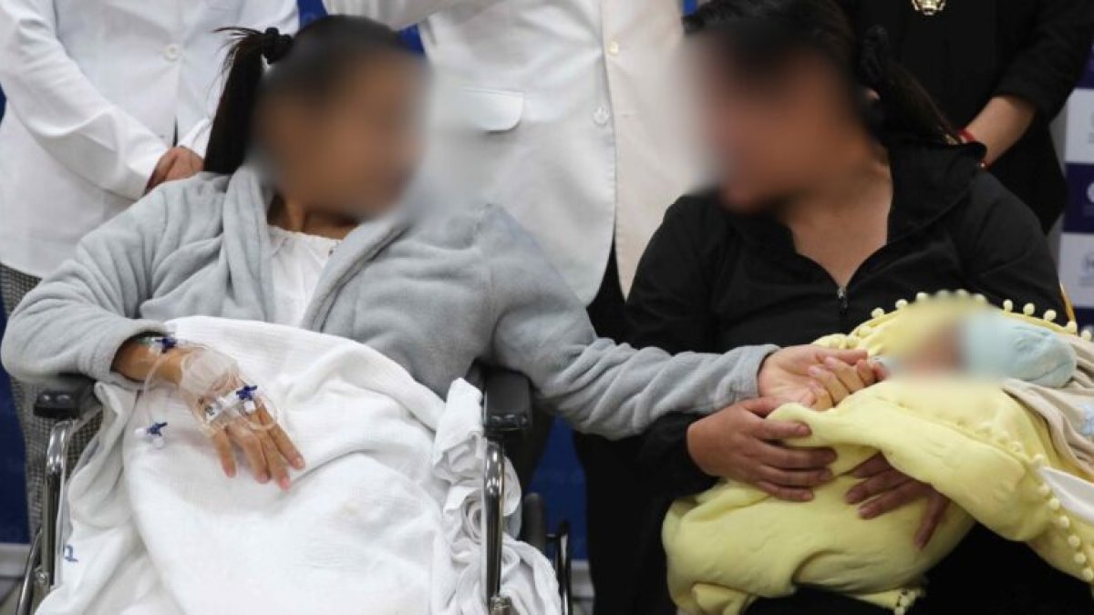 La bebé Aylin es cargada por su abuela Janet Vergara (d) este miércoles, el Hospital Cayetano Heredia de Lima (Perú)