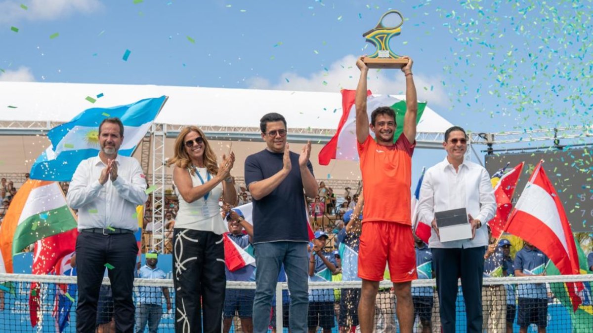 Mariano Navone sostiene trofeo de campeón.