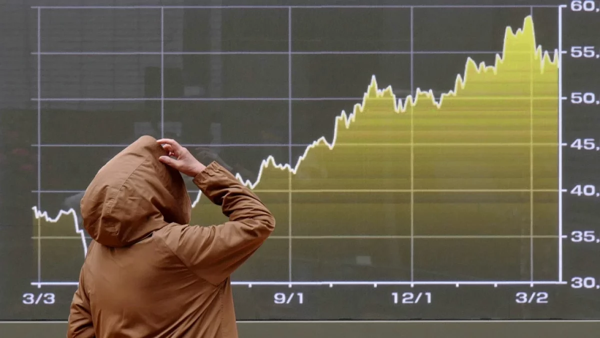 Una persona mira una pantalla con una gráfica del índice bursátil japonés Nikkei en una correduría en Tokio, el lunes 23 de marzo de 2026. (AP Foto/Eugene Hoshiko)