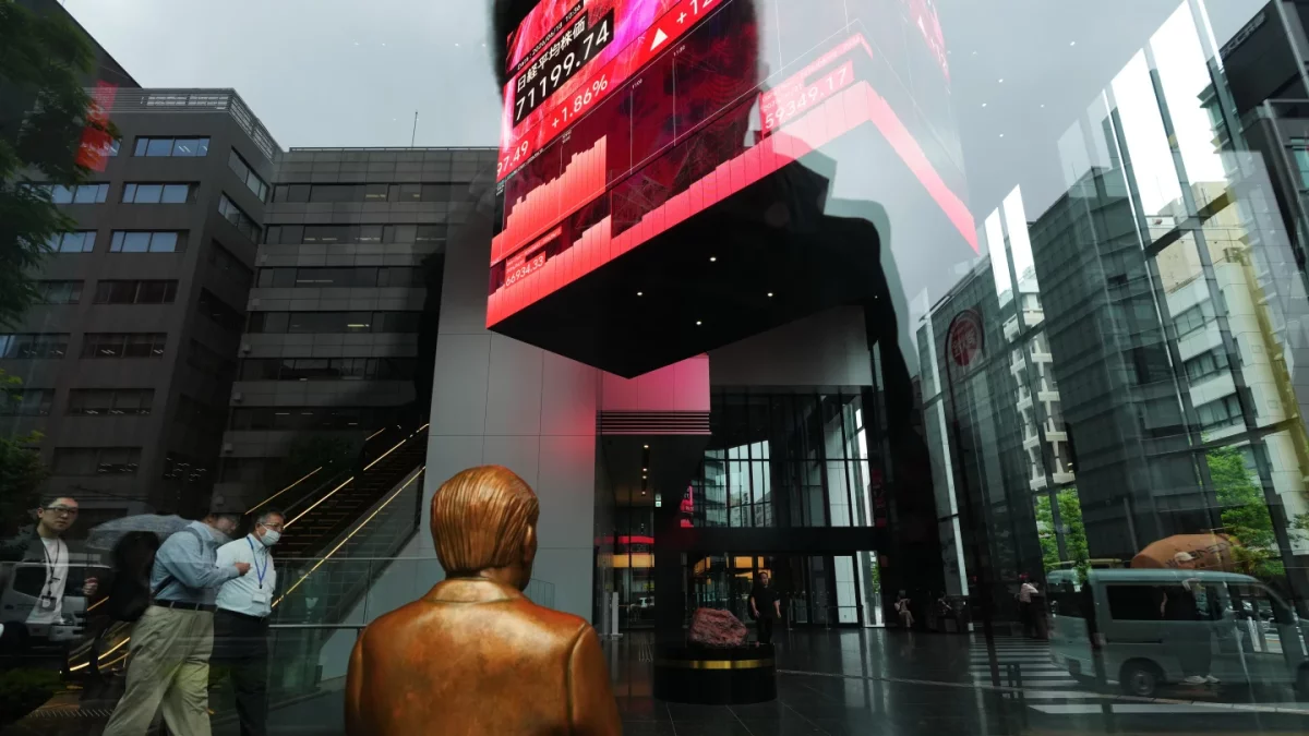 Una estatua se encuentra sobre un banco cerca de monitores que muestran el índice Nikkei 225 de Japón, en un edificio de oficinas de Tokio, el jueves 18 de junio de 2026