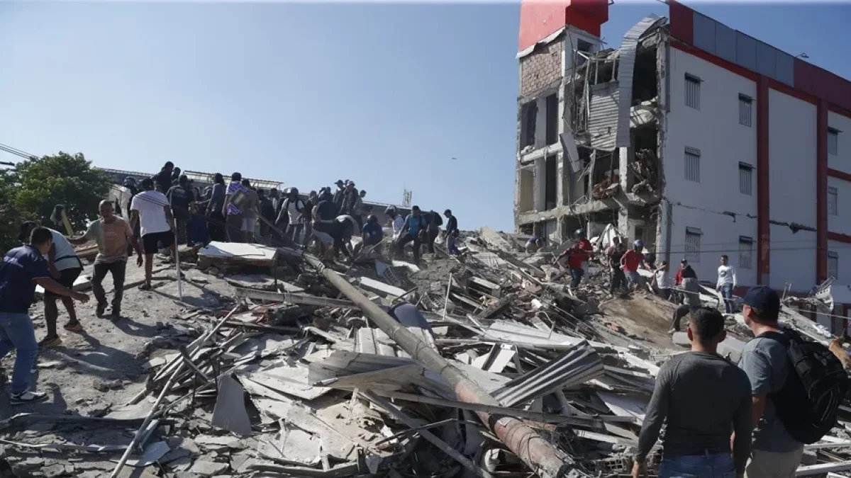 Personas caminan sobre los escombros de un edificio colapsado este lunes, en Cali (Colombia). EFE/ Ernesto Guzmán