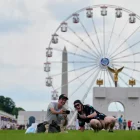 Christine Bayly, a la derecha, y Jason Brown, a la izquierda, toman una foto mientras almuerzan en el National Mall, junto a la noria y una réplica del arco de triunfo, durante la Gran Feria Estatal de Estados Unidos, el viernes 26 de junio de 2026 en Washington. (AP Foto/Carolyn Kaster)