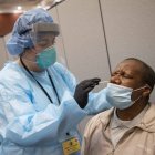 FILE- In this May 13, 2020, file photo, registered nurse Stephanie Mundo conducts a COVID-19 test at the Abyssinian Baptist Church in the Harlem neighborhood of New York. New York broke a COVID-19 testing record Friday, July 31, 2020, by conducting 82,737 tests, the highest number ever conducted in a single day in the state, Gov. Andrew Cuomo announced on Saturday in a written statement. (AP Photo/Mary Altaffer, File)