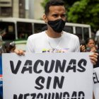 AME1359. CARACAS (VENEZUELA), 28/05/2021.- Un joven muestra un cartel de protesta durante una manifestación para exigir plan de vacunación de covid-19 hoy, en la Plaza José Martí de Caracas (Venezuela). Los venezolanos, cansados de ver como las promesas de vacunación por parte del Gobierno se desvanecen y con la paciencia ya agotada, salieron a la calle este viernes a reclamar un plan de inmunización anticovid y transparencia en un proceso que, por el momento, es desconocido para la mayoría. Plazos incumplidos, cifras irreales, compromisos que acabaron en nada y falta de información veraz son solo algunas de las razones que han llevado a los ciudadanos a implorar, de manera desesperada, la vacuna prometida. EFE/ Rayner Peña