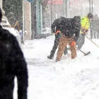Personas retiran nieve de una acera, el 25 de enero de 2026, en Toronto (Canadá). EFE