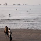 En pleno estrecho de Ormuz, en Irán,  se ven algunos barcos desde la playa.  AP