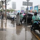 Motoristas y ciudadanos se resguardan de la lluvia bajo el elevado de la avenida John F. Kennedy durante los aguaceros registrados este sábado en Santo Domingo. Foto: Guillermo Burgos.