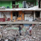 Dos residentes entre los escombros de uno de los bloques de viviendas derrumbado por los terremotos en la localidad de Catia La Mar, en el estado costero de La Guaira (Venezuela) este jueves.  EFE/ Ronald Pena R.