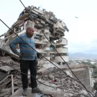 Un hombre permanece de pie entre los escombros de un edificio derrumbado tras un terremoto en La Guaira, Venezuela,