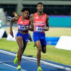 El atleta Christopher Melenciano (295) le pasa el bastón a Marileidy Paulino, el lunes en la noche