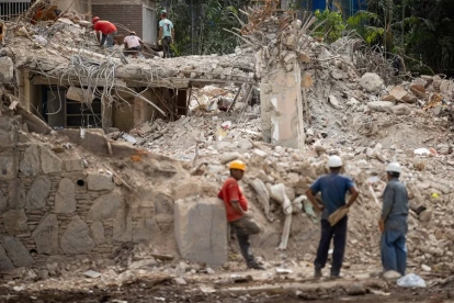 Personas retiran escombros de un edificio afectado en Caracas por el doble terremoto del pasado 24 de junio. EFE/ Ronald Peña R