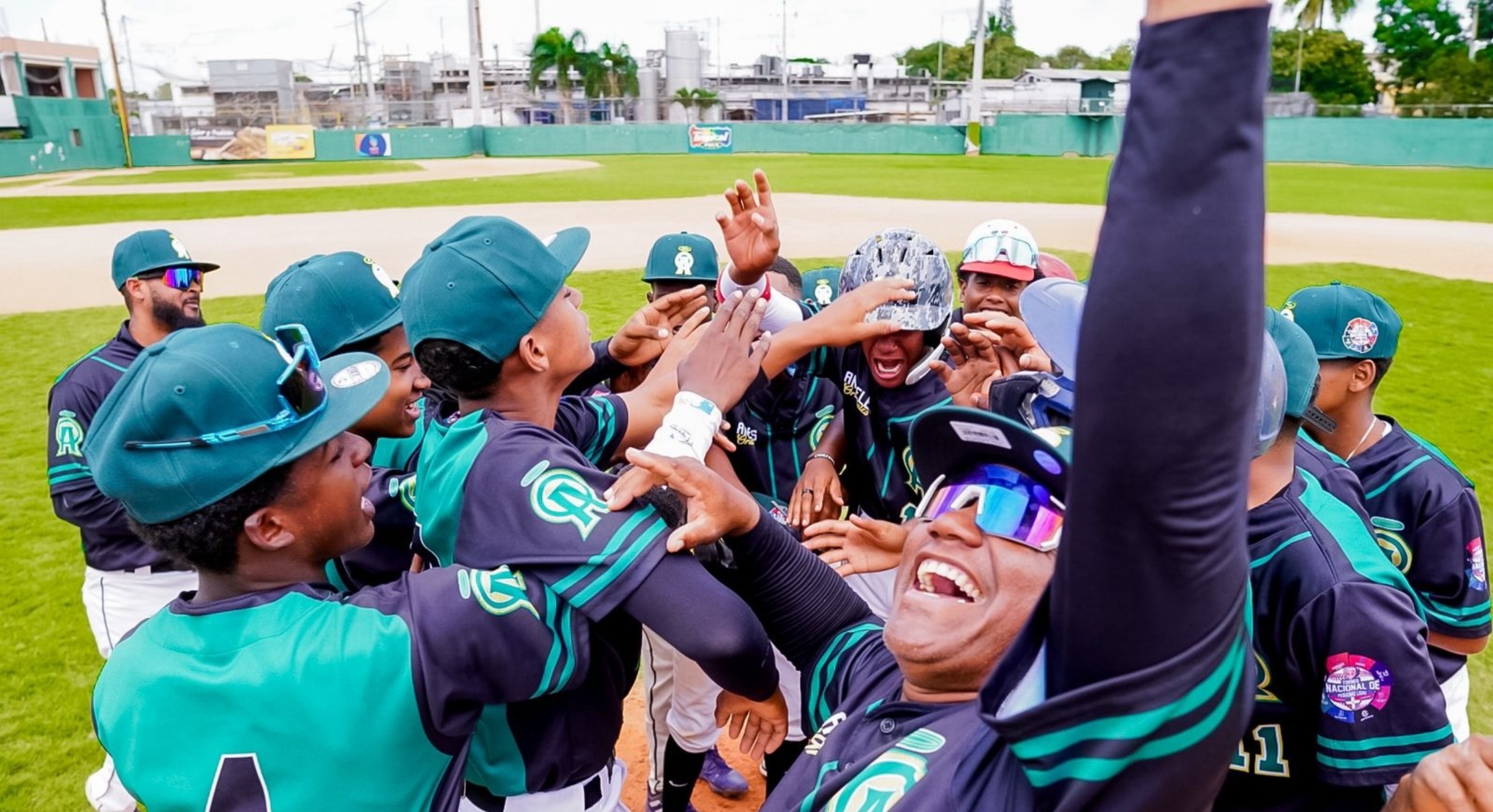 Jugadores y dirigentes de los Angeles Orientales celebran tras vencer a los Leones del Norte en partido decisivo para avanzar a las semifinales del Torneo Nacional de Béisbol de Pequeñas Ligas, dedicado a la vicepresidenta Raquel Peña.