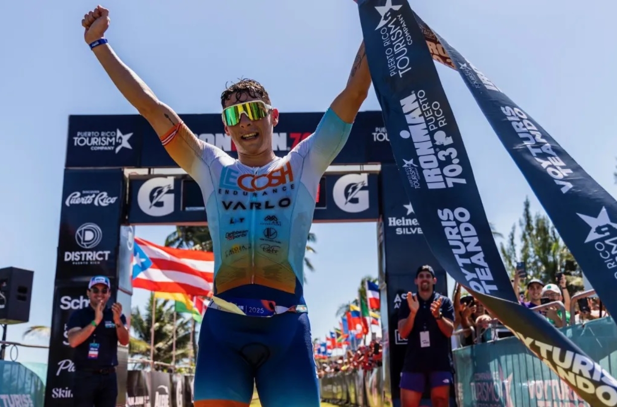 Javier Figueroa levanta brazos en señal de triunfo, al   ganar  Ironman 70.3 Cap Cana.