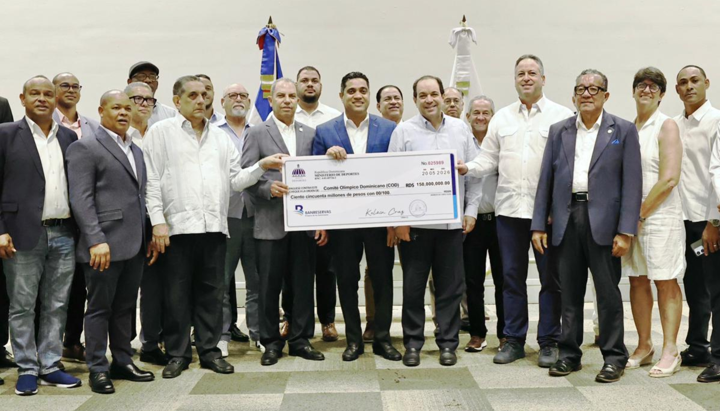 Kelvin Cruz habla durante el acto de entrega de la última partida para la preparación de los atletas.
Kelvin Cruz, ministro de Deportes, acompañado de otros funcionarios del Ministerio de Deportes y dirigentes del COD, muestra cheque simbólico con la partida de  recursos entregados al  organismo olímpico para la preparación de los atletas que representarán al país en los Juegos Centroamericanos y del Caribe Santo Domingo 2026.