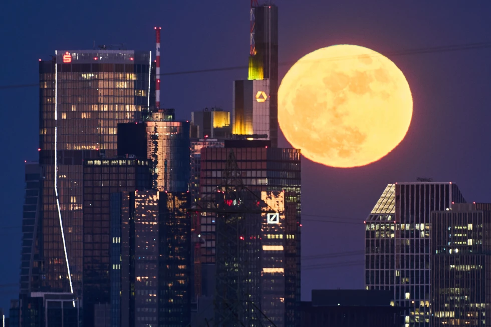 La luna llena se alza detrás de los edificios del distrito bancario de Frankfurt, Alemania, el viernes 1 de mayo de 2026. (Foto AP/Michael Probst)