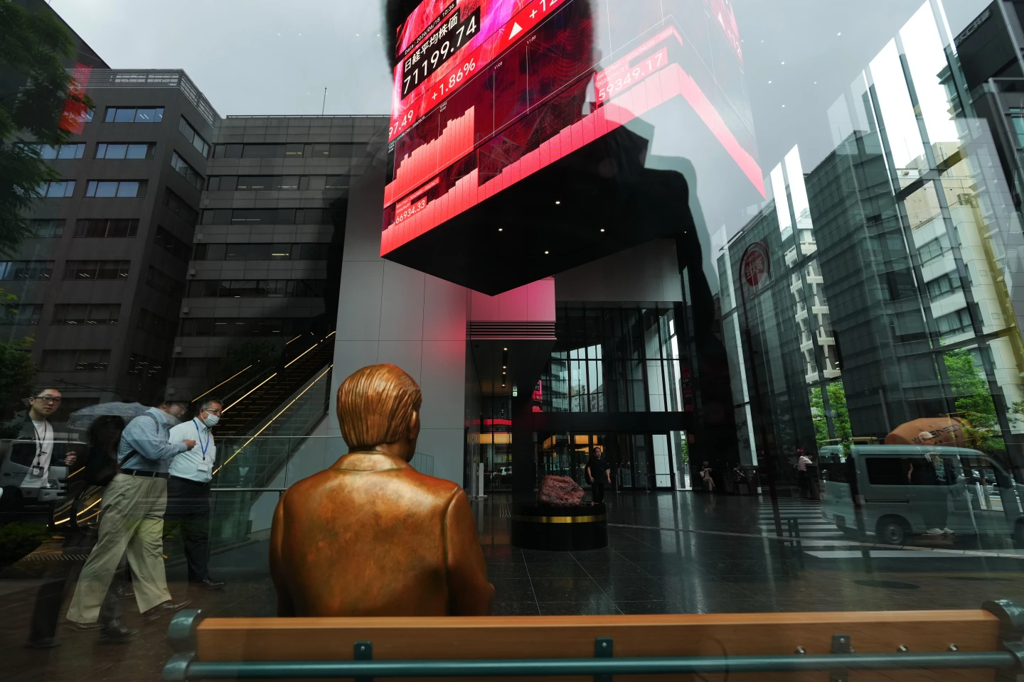 Una estatua se encuentra sobre un banco cerca de monitores que muestran el índice Nikkei 225 de Japón, en un edificio de oficinas de Tokio, el jueves 18 de junio de 2026