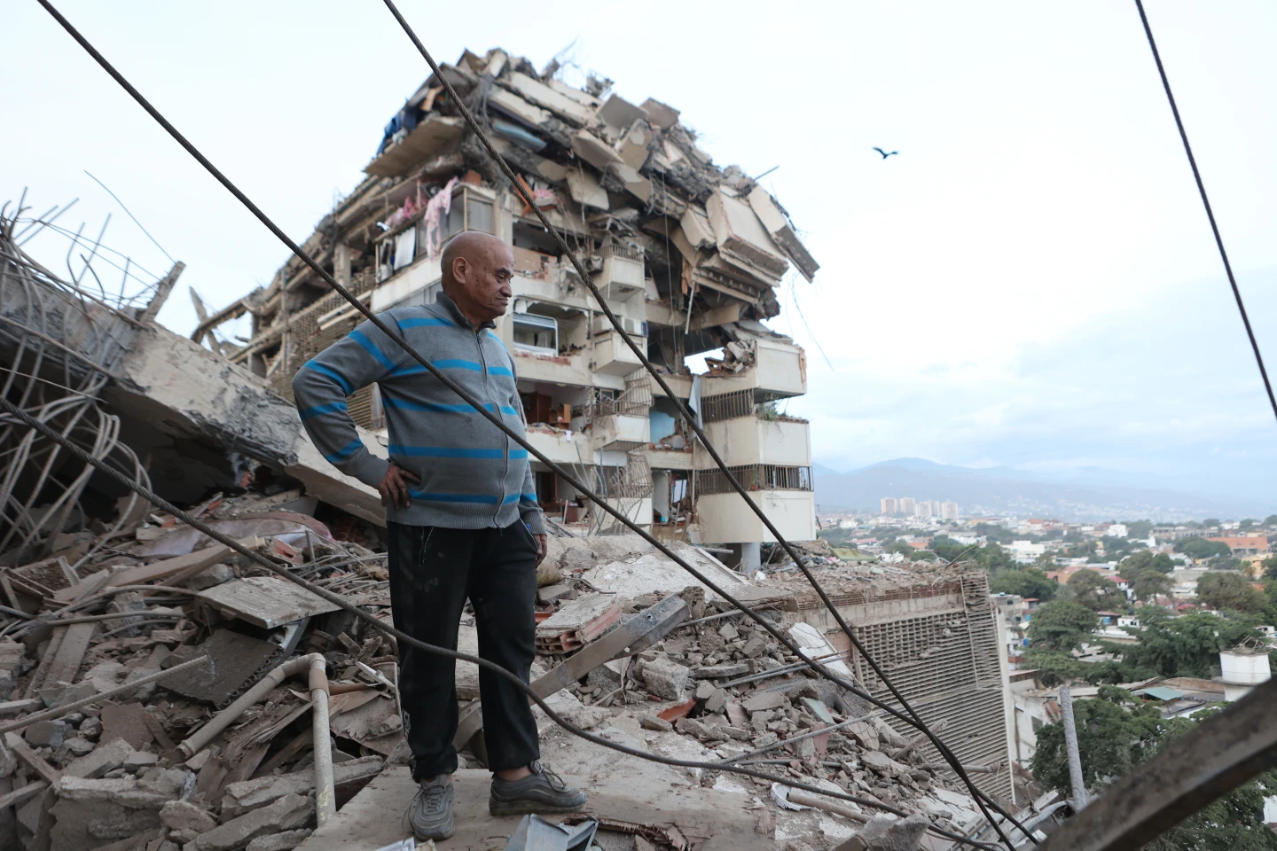 Un hombre permanece de pie entre los escombros de un edificio derrumbado tras un terremoto en La Guaira, Venezuela,