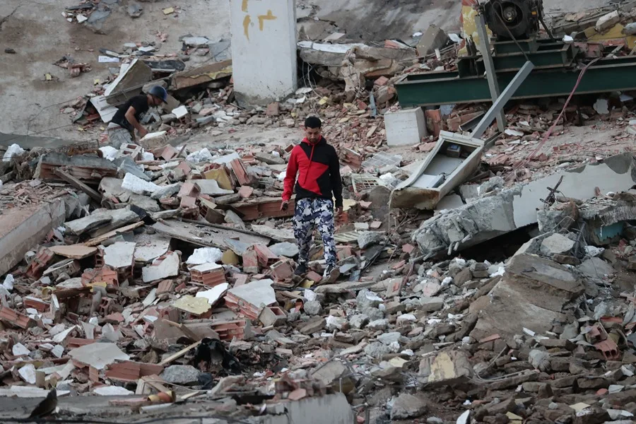 Un residente camina entre los escombros de edificios derrumbados por los terremotos, en la localidad de Catia La Mar, en el estado costero de La Guaira (Venezuela), este jueves. EFE/ Ronald Pena R.