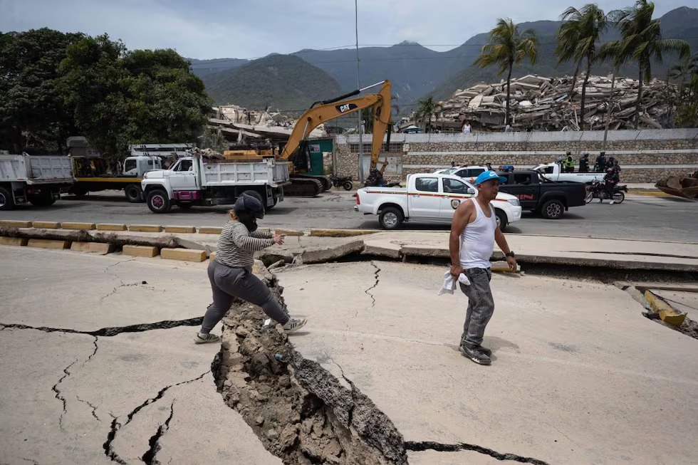La gente camina entre grietas este jueves tras el terremoto de La Guaira (Venezuela). El número de muertos por los dos terremotos del miércoles en Venezuela aumentó a 188 y 1.520 heridos. (EFE).