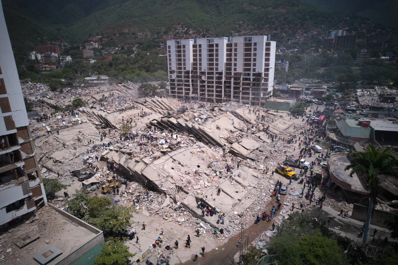 Residentes y equipos de rescate buscan entre los escombros dos días después de que un terremoto sacudiera La Guaira, Venezuela, el viernes 26 de junio de 2026. (Foto AP/Juan Pablo Arez)