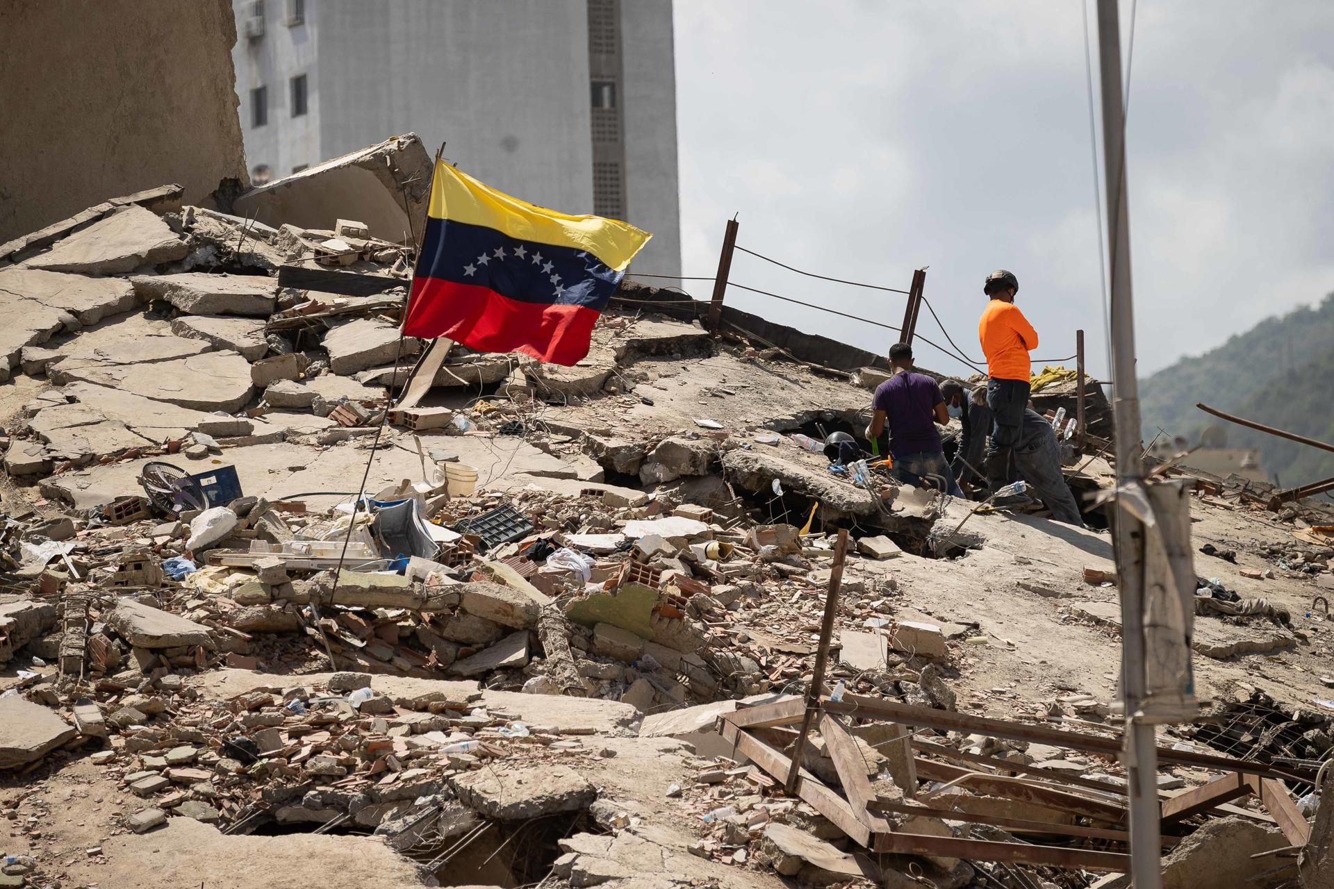 Voluntarios realizan labores de búsqueda en los escombros de un edificio este lunes, en La Guaira (Venezuela). Han pasado cinco días desde el doble terremoto de magnitud 7,2 y 7,5 que sacudió el norte de Venezuela y los sobrevivientes sienten que ya no les queda nada para vivir en el estado costero La Guaira, el más afectado por el desastre. EFE/ Ronald Peña R.